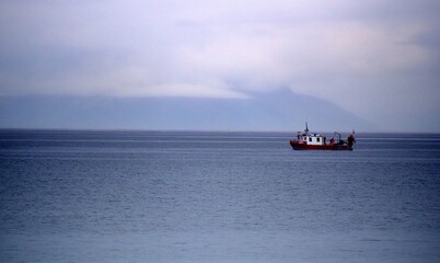 Obraz premium Fishing boat off the coast at Prestwick on a rainy day 