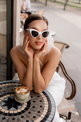 Summer fashion look. Woman in a white suit and retro sunglasse. Close-up portrait