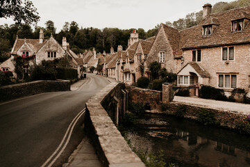 Castle Combe traditional English village with pretty bridge on a summer day. Nobody and no car on the street. 