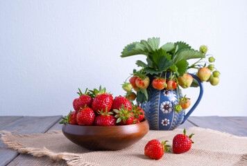 ripe sweet strawberries in a wooden bowl on a wooden table, in a rustic style