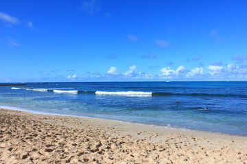 ハワイ・オワフ島、ワイキキビーチ。青い海、青い空、白い雲	。
