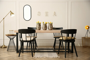 Stylish wooden dining table and chairs in room. Interior design