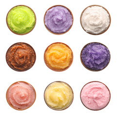 Set with different body scrubs in bowls on white background, top view