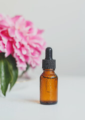 A brown glass bottle of serum, essential oil or other cosmetic product. Natural organic cosmetic packaging, skin care concept.