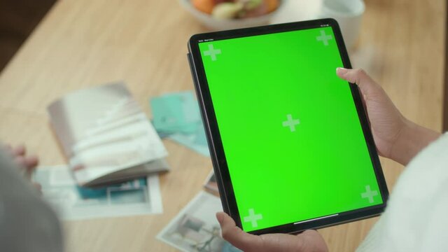 Person holding tablet with green chroma key screen, Birmingham, England, UK