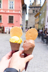 ice cream in the city. Couple holding two ice creams in their hands in the heart of the medieval city, Sighisoara, Romania