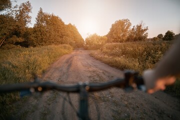 Point of view bike riding at the rural area during summer sunset. Concept of summertime sport...
