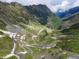 Aerial view of mounrain road Transfagarasan in Romania in summer, difficult curvy rock way © Elena
