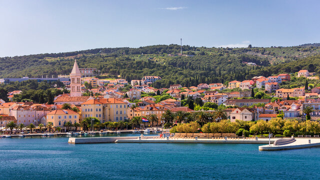 Supetar city in Brac island, Croatia. View from the sea. Picturesque scenic view on Supetar on Brac island, Croatia. Panoramic view on harbor of town Supetar from the side of sea. Brac, Croatia.