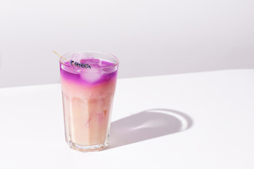 Iced coffee lavender drink on white background. Lavender purple honey latte.