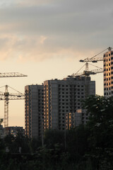 Fototapeta na wymiar Construction of a multi-storey residential panel houses at sunset.