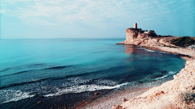 Costal landscape with tower on cliff. Xarco beach, La Vila Joiosa in Alicante province, Spain.