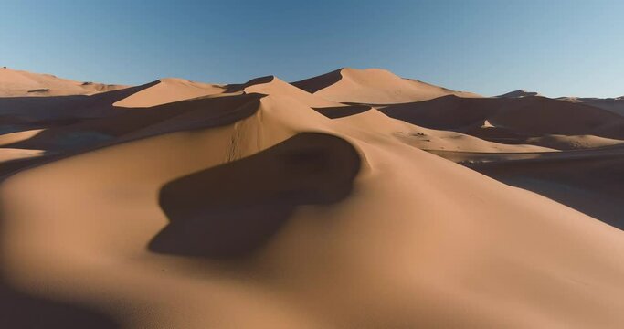 Drought. Climate change.Climate emergency.Global warming.Spectacular epic aerial fly over view of endless sand dunes of the Namib desert 