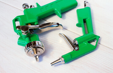 Green air compressor gun. Isolated on a wooden background