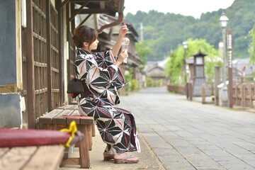 小江戸佐原の町並みで風鈴を見つめる若い浴衣姿の女性	