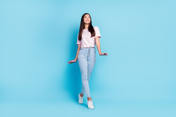 Fototapeta na wymiar Full size photo of young attractive girl happy positive smile look empty space go walk isolated over blue color background