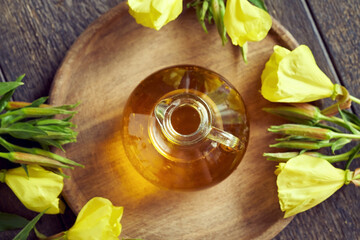 A bottle of evening primrose oil with fresh Oenothera biennis flowers. Healthy nutritional supplement.