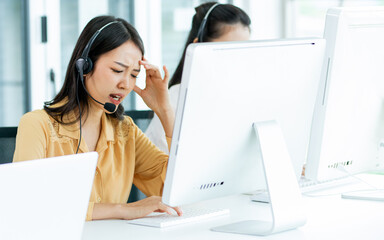 Asian beautiful attractive female call center stressful working with pressure with headsets,...