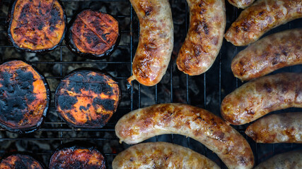 pork sausage grill with fried eggplants on a wire rack are cooked on charcoal outdoors