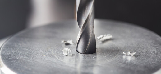 metal drill bit make holes in steel billet on industrial drilling machine. Metal work industry....