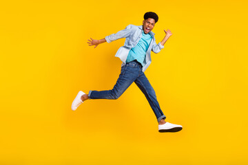 Fototapeta na wymiar Full length body size view of attractive funny cheerful guy jumping running good mood isolated over bright yellow color background