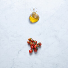 Tomatoes and Oil, Isolated on Marble Background – Pasta Ingredients from Italy, Extra Virgin Olive Oil, Cherry Tomatoes (Ciliegini) with Branch on Stone Kitchen Table – Close-Up Macro, Top View