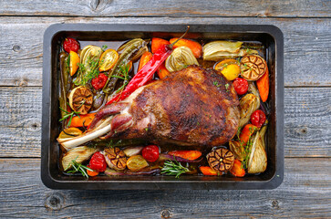 Traditional barbecue lamb shoulder with vegetables and chili served as top view on a rustic metal...