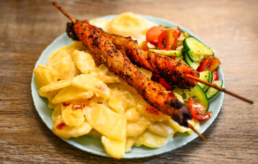 Delicious potatoes and skewers with salad and egg