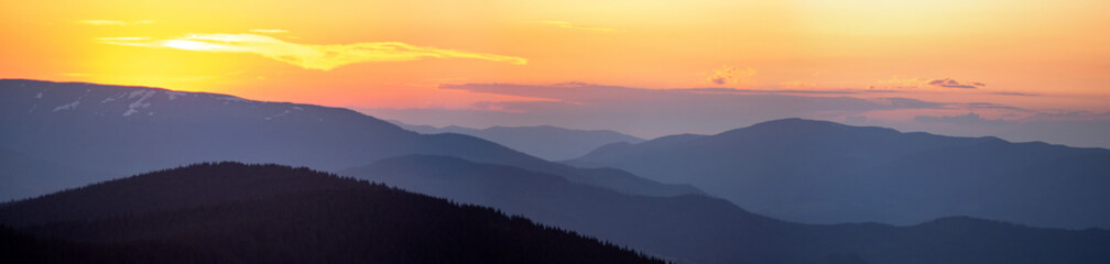 Panorama, smoky silhouette of the Carpathian mountains at sunset