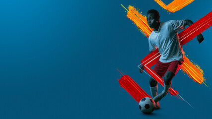Young man, soccer footbal player training isolated in neon light background.