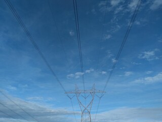 high voltage power grid on blue sky background