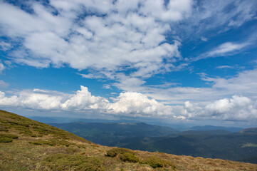 Fototapeta na wymiar Green meadow and blue sky in the Carpathian mountains in Ukraine