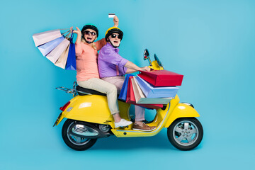 Full size photo of grey haired couple retired pensioner husband wife helmet mall debit card customer ride isolated on blue color background