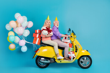 Portrait of two amazed elderly retired pensioners riding moped bringing gifts holiday isolated over...