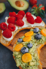 Breakfast, Croissant sandwiches with berries and avocado, Close up, Selective focus, Delicious summer food, Top view on a dark background