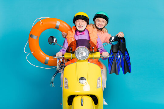 Photo of grey haired retired old couple married people holiday biker hold rubber inflatable circle helmet isolated on blue color background