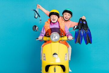 Photo of happy amazed grey haired retired pensioner couple wear helmet hold diver equipment biker isolated on blue color background - Powered by Adobe