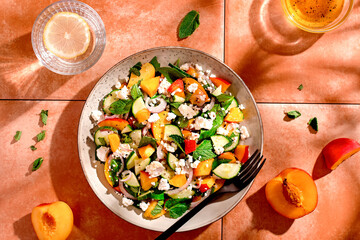 Summer peach and cheese salad on tile table, top view