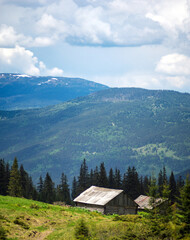 Panorama of a mountain meadow, blue sky and clouds. Travel and vacation in the mountains.