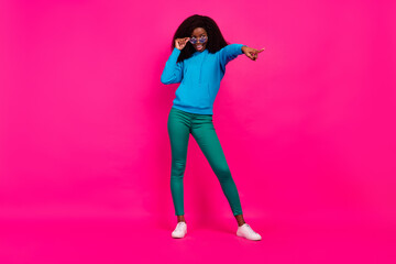 Photo of sweet pretty dark skin woman dressed blue sweatshirt arm eyewear pointing finger empty space isolated pink color background
