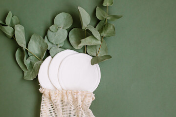 Makeup remover cotton pad on green background Eucalyptus plant © Hanna Chayka