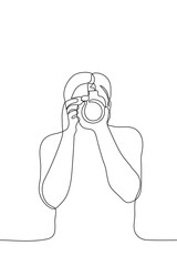 professional photographer with camera makes a photo of the viewer - one line drawing. photography concept, video filming, photographer at work, photojournalist makes content
