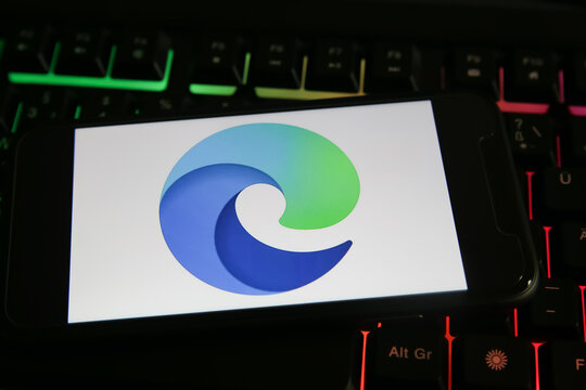 Viersen, Germany - June 9. 2021: Closeup of mobile phone screen with logo icon of microsoft edge browser on computer keyboard