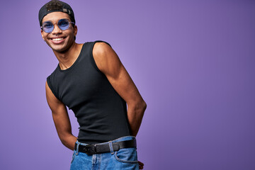 Smiling cheerful male in in blue glasses portrait. Happy young transgender man in casual pose