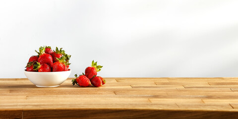 Fresh red fruits on wooden desk and wall with shadows 