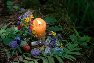 candle, mineral gemstones, flowers on dark forest natural background. Magic, Witchcraft, spiritual practice. pagan, Wiccan, Slavic traditions. esoteric ritual for Midsummer, Litha - obrazy, fototapety, plakaty