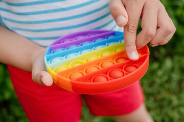 Antistress pop it toy. Rainbow sensory fidget in the child hand . New trendy silicone toy. Learning colors, counting for children.