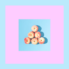 Fresh organic peaches on a pastel blue background. Summer fruits concept or billiard balls creative...