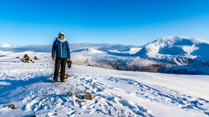 Ingeborg Kuhn auf dem frisch verschneiten Hügel über dem Fjord, mit Aussicht in die Berge von...