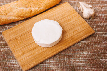 DIY baked cheese camembert instruction step by step. step 1 unpacking camembert.camembert in white paper packaging.cheese with white mold.moldy cheese